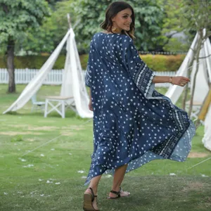 Vue détaillée de la robe caftan de plage imprimée bleue dans le décor extérieur du resort.