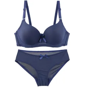 Dark blue seamless bra and panties detail view, smooth fabric with cute bow accent.