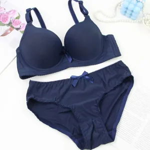 Detailed view of dark blue seamless push-up bra and matching panties with cute bow decor.