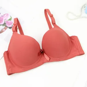 Close-up detail of the smooth seamless red bra featuring adjustable straps and front bow.