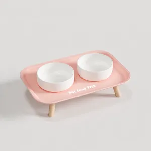 Gamelles doubles en céramique pour animaux avec support en bois et joli plateau rose.