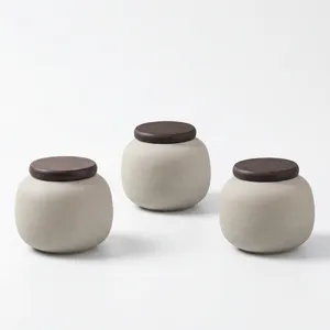 Vue détaillée de trois urnes en céramique pour animaux avec couvercle en bois, design épuré.