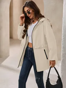 Detailed view of women's beige hooded waterproof windbreaker jacket with zipper and pockets.