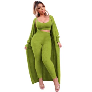Detalle del conjunto de ropa de estar verde de felpa de tres piezas, top corto, pantalón y cárdigan.