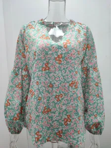 Détail en gros plan de chemisier mousseline floral pour femme col V manches lanterne haut.