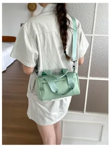 Bolso bandolera cilíndrico minimalista para mujer en verde claro, elegante y casual para el día a día.
