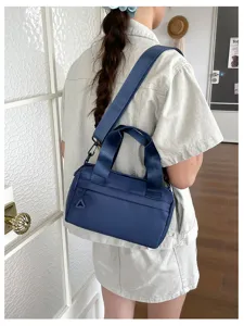 Vista detallada del bolso bandolera informal de nailon azul para mujer llevado por la modelo.
