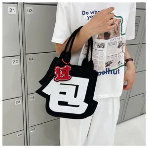 Detailed view of creative black felt handbag featuring bold contrast lettering for daily commute.