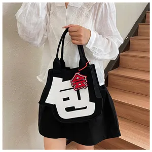 Detailed view of creative black felt tote bag featuring bold white character design for trendy daily use.