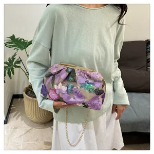 Vue détaillée d'un sac à bandoulière élégant brodé de sequins violets avec chaîne dorée.