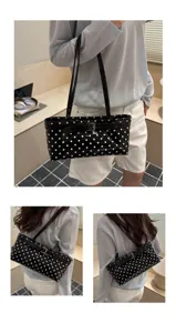 Black patent leather shoulder bag with white polka dots, elegant underarm style detail view.