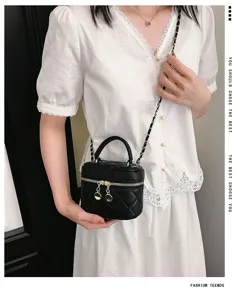 Detail view of the chic black quilted crossbody bag with a stylish chain strap and top handle.