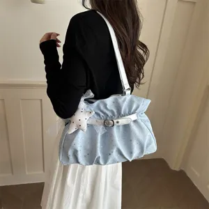 Chic light blue star print shoulder bag with silver strap and cute star pendant detail view.