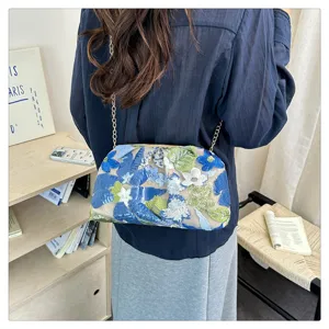 Sac bandoulière chic brodé de fleurs bleues avec chaîne élégante pour style estival.