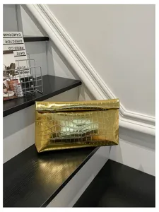 Detailed view of a stylish metallic gold crocodile pattern clutch bag for women daily use.