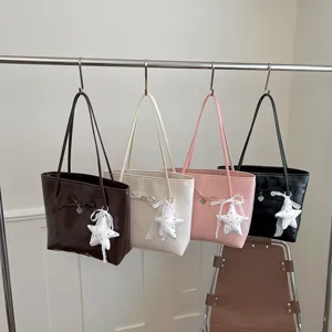 Detail view of chic women tote bucket bag featuring cute bow and soft star plush pendant charm.