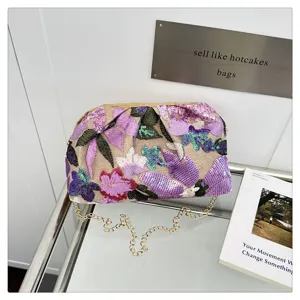 Vue détaillée de l'élégant sac clutch brodé de sequins avec une belle bandoulière chaîne.
