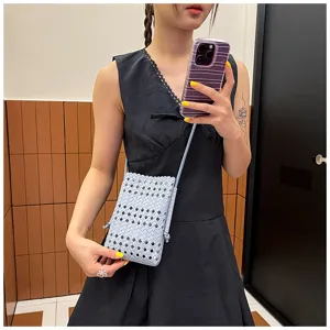 Vue détaillée du sac mini bandoulière élégant en cuir souple avec tissage ajouré pour l'été.