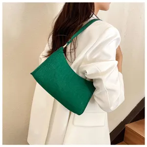 Nahaufnahme der dunkelgrünen Schultertasche mit strukturierter Oberfläche und elegantem Trageriemen.