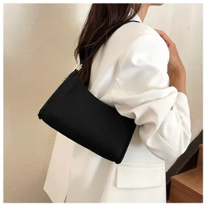 Detailansicht einer stilvollen schwarzen Schultertasche am Modell, schick und minimalistisch.
