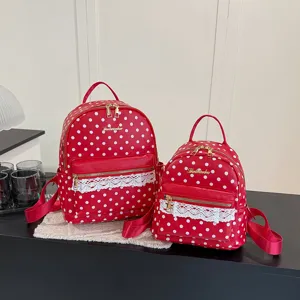 Detailed view of red polka dot backpack with lace trim, cute stylish student school bag.