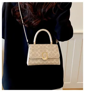 Elegante bolso bandolera beige con monograma y cierre metálico elegante para diario.