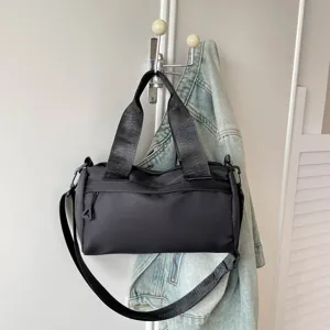 Bolso cruzado negro minimalista, bolsa de barril informal con correa ancha para uso diario.
