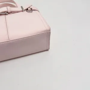 Primo piano dettagliato della borsa rosa da lavoro con fibbia in metallo elegante.