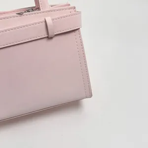 Vista dettagliata di una elegante borsa da donna rosa per pendolari con fibbia decorativa.