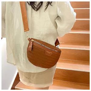 Détail de sac bandoulière en cuir tressé marron, sac de loisirs élégant avec sangle large.