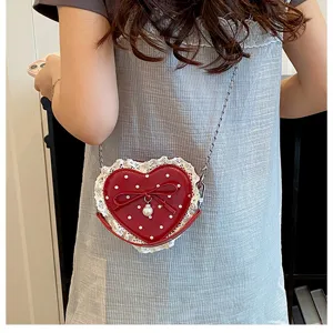 Detail view of mini red heart polka dot crossbody bag with sweet white lace and bow.