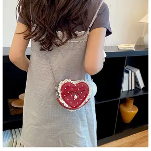 Joli sac bandoulière rouge en forme de cœur avec pois, bordure dentelée et nœud élégant.