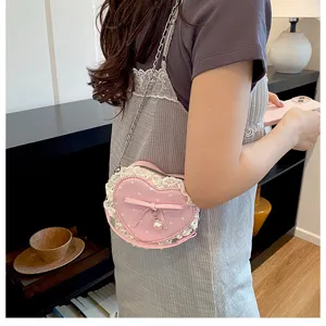 Charmante petite sacoche bandoulière rose en forme de cœur avec nœud et pendentif perle.