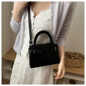 Minimalist black top handle crossbody bag featuring chic metal buckle details for daily wear.