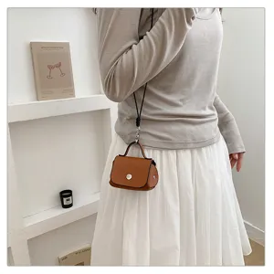 Kleine bruine lederen crossbody tas met zwarte band, stijlvol minimalistisch modeaccessoire.