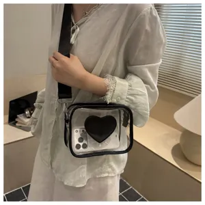 Vue détaillée d'un sac bandoulière en PVC transparent avec motif de cœur noir et large sangle.