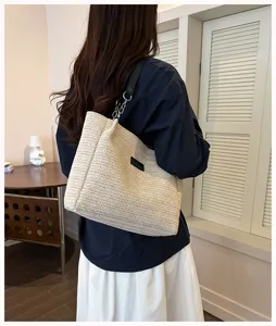 Detailansicht der beige geflochtenen Strohtasche mit grossem Fassungsvermögen und Kettengriff.