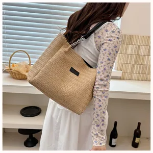 Detailansicht der Sommer Stroh Tote Tasche mit Kettengurt und schwarzem Etikett Design.