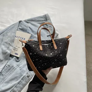 Detailansicht der schwarzen Segeltuchtasche mit Sternenmuster, modische Umhängetasche.