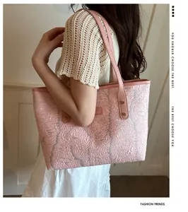Pink textured tote bag detail view, showing soft crinkled fabric and sturdy leather shoulder strap.