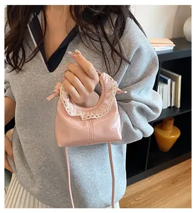 Detailed shot of a cute pink cloud handbag with delicate lace trim and thin strap.