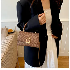 Braune Monogramm Schultertasche Detail, elegantes Design mit Metallschließe für Damen.