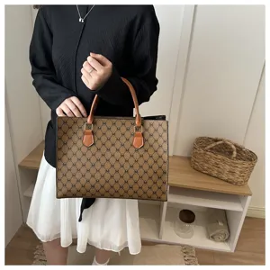 Dettaglio di borsa tote con monogramma chic in ecopelle marrone e raffinato motivo M.