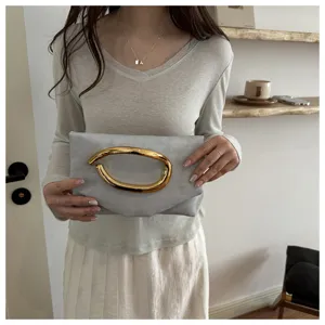 Einfashionige minimalistische Damen-Clutch mit einzigartigem goldenen Skulptur-Griff.