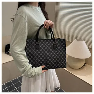 Vista dettagliata della borsa tote nera da donna elegante con stampa monogramma.