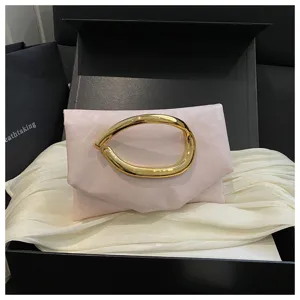 Detailaufnahme einer stilvollen rosa Clutch mit einzigartigem goldenen Metallgriff.