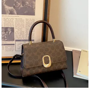 Klassische braune Monogramm Schultertasche mit Henkel und elegantem Metallverschluss Detail.