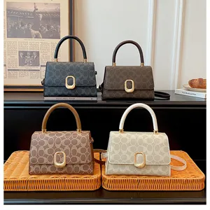 Vista detallada de elegantes bolsos cruzados con monograma colocados en bandejas tejidas.