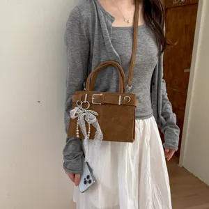 Vista dettagliata della borsa da donna retrò con elegante fibbia e ciondolo di perle.