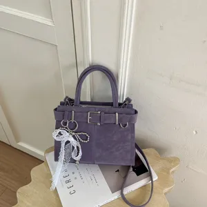 Borsa a mano e tracolla elegante viola in pelle sintetica con fibbia e ciondolo di perle.